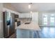 Bright kitchen with white cabinets, stainless steel appliances, an island, and contemporary pendant lighting at 13588 Se 102Nd Ct, Belleview, FL 34420