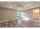 Cozy main bedroom featuring a ceiling fan, tray ceiling, hardwood floors, and an en-suite bathroom at 13588 Se 102Nd Ct, Belleview, FL 34420