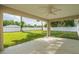 Covered patio area with a ceiling fan overlooking a spacious backyard with trees and a white fence at 13588 Se 102Nd Ct, Belleview, FL 34420
