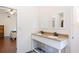 Bathroom with double sinks and wooden floors visible from the doorway and a view to the bedroom at 16295 W Highway 40, Ocala, FL 34481