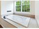 Bright bathroom with a large bathtub, tile, and large window looking out on green trees at 16295 W Highway 40, Ocala, FL 34481