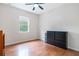 Bedroom with dresser, storage basket, bright window, ceiling fan and hardwood floors at 16295 W Highway 40, Ocala, FL 34481