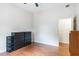 Wood-floored bedroom featuring black dresser, storage basket, and doorway at 16295 W Highway 40, Ocala, FL 34481