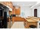 Kitchen with bright tile floor, wooden cabinets, stainless steel oven and cooktop, and a farmhouse sink at 16295 W Highway 40, Ocala, FL 34481