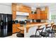 An open kitchen featuring warm wood cabinets, stainless steel appliances, and breakfast bar with seating at 16295 W Highway 40, Ocala, FL 34481