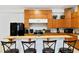 A kitchen with wooden cabinetry, stainless steel appliances, and a bar area with four stools at 16295 W Highway 40, Ocala, FL 34481