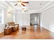 Bright living room with light walls, hardwood floors, and a comfortable brown leather couch at 16295 W Highway 40, Ocala, FL 34481