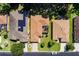 Aerial view of a home with a screened-in lanai, an attached garage, a green lawn, and mature landscaping at 16299 Sw 14Th Avenue Rd, Ocala, FL 34473