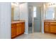 Bathroom featuring double vanities, a walk-in shower with glass door, and tile flooring at 16299 Sw 14Th Avenue Rd, Ocala, FL 34473