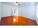 Bedroom with wood floors, ceiling fan, and open doorway at 16299 Sw 14Th Avenue Rd, Ocala, FL 34473