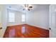 Bedroom with wood flooring, ceiling fan, and two windows at 16299 Sw 14Th Avenue Rd, Ocala, FL 34473