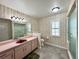 Bathroom with walk-in shower, pink vanity and patterned wall paper at 1711 Sw 63Rd St Rd, Ocala, FL 34476