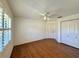 A bright bedroom featuring hardwood floors, a ceiling fan, and white trim windows at 1711 Sw 63Rd St Rd, Ocala, FL 34476