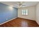 Bedroom showcasing hardwood floors, ceiling fan, and a serene blue accent wall at 1711 Sw 63Rd St Rd, Ocala, FL 34476