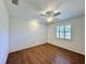 A bright bedroom featuring hardwood floors, a ceiling fan, and a window with white trim at 1711 Sw 63Rd St Rd, Ocala, FL 34476