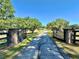 Gated driveway leading to a beautiful home with mature trees and lush landscaping at 1711 Sw 63Rd St Rd, Ocala, FL 34476