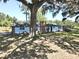 Charming brick and light blue house with large tree and covered ramp in the front yard at 1711 Sw 63Rd St Rd, Ocala, FL 34476
