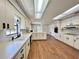 Open kitchen features white cabinets, a long island, wood floors, and natural light at 1711 Sw 63Rd St Rd, Ocala, FL 34476