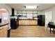 Well-lit kitchen featuring wood cabinets, black appliances, open shelves, and a clean, modern design at 1711 Sw 63Rd St Rd, Ocala, FL 34476