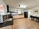 Bright kitchen with wood cabinets, black appliances, open shelving and modern black range hood at 1711 Sw 63Rd St Rd, Ocala, FL 34476