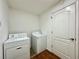 A laundry room with a white washer and dryer set, and a white door on brown floors at 1711 Sw 63Rd St Rd, Ocala, FL 34476