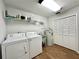 Functional laundry room equipped with washer, dryer, utility sink, and ample storage shelves at 1711 Sw 63Rd St Rd, Ocala, FL 34476