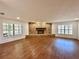 Spacious living room featuring a brick fireplace, hardwood floors, and bright windows at 1711 Sw 63Rd St Rd, Ocala, FL 34476