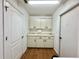 A utility room with white cabinets and countertops, contrasted by the brown wood look floors at 1711 Sw 63Rd St Rd, Ocala, FL 34476