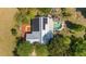 Aerial view of a beautiful home with solar panels and a swimming pool nestled amongst lush greenery at 18695 Ne 5Th Terrace Rd, Citra, FL 32113