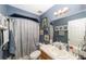 Nautical-themed bathroom with patterned shower curtain and wall art above the toilet and sink with white countertop at 18695 Ne 5Th Terrace Rd, Citra, FL 32113