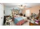 Cozy bedroom with pastel-colored walls, decorative headboard, ceiling fan and unique decorations displayed throughout at 18695 Ne 5Th Terrace Rd, Citra, FL 32113