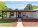 Inviting front porch with rocking chair, farmhouse decor, and a vibrant purple front door at 18695 Ne 5Th Terrace Rd, Citra, FL 32113
