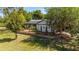 Inviting home with a metal roof, enhanced by well-maintained landscaping and mature trees, creating a peaceful ambiance at 18695 Ne 5Th Terrace Rd, Citra, FL 32113