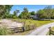 Welcoming gated entrance with lush landscaping, leading to a charming home nestled in a serene environment at 18695 Ne 5Th Terrace Rd, Citra, FL 32113