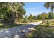 Picturesque property entrance with mature trees, green pastures, and a charming home in the peaceful countryside at 18695 Ne 5Th Terrace Rd, Citra, FL 32113
