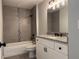 Modern bathroom with tiled walls, a bathtub with shower, a sink, and vanity with granite countertop at 203 Locust Pass, Ocala, FL 34472