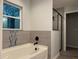 Bright bathroom features a soaking tub with modern fixtures and tiled walls at 203 Locust Pass, Ocala, FL 34472