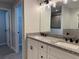 Bathroom with a double sink vanity, granite countertops, and a walk-in shower at 203 Locust Pass, Ocala, FL 34472