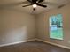 Bedroom with wood-look floors, neutral walls, base molding, a ceiling fan, and a window at 203 Locust Pass, Ocala, FL 34472