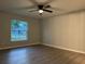 Bedroom with wood-look floors, neutral walls, base molding, and a ceiling fan at 203 Locust Pass, Ocala, FL 34472