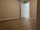 Empty bedroom boasts wood-look floors, neutral-colored walls, with a door opening into the hallway at 203 Locust Pass, Ocala, FL 34472