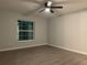 Bedroom with a ceiling fan, window, and wood flooring at 203 Locust Pass, Ocala, FL 34472