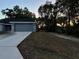 Side view of a single-story home, with two-car garage, minimal landscaping, and long driveway at 203 Locust Pass, Ocala, FL 34472