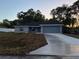 Charming single-story home features a well manicured lawn, a concrete driveway, and attached two-car garage at 203 Locust Pass, Ocala, FL 34472
