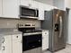 Kitchen with white cabinets, stainless steel appliances, and granite countertops at 203 Locust Pass, Ocala, FL 34472