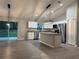 Open kitchen with white cabinets, stainless appliances, granite countertops, and a sliding glass door at 203 Locust Pass, Ocala, FL 34472
