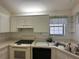 Functional kitchen with white appliances, white cabinets, and a stainless steel sink at 2127 N.E. 40Th Ave., Ocala, FL 34470