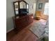 Bright bedroom featuring wood floors, dresser with mirror, and comfortable chair at 2127 N.E. 40Th Ave., Ocala, FL 34470
