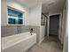 Well lit bathroom featuring soaking tub, shower with glass door, and custom tile work at 227 Locust Rd, Ocala, FL 34472