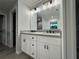 Well-lit bathroom featuring double vanity with granite countertop and updated fixtures at 227 Locust Rd, Ocala, FL 34472